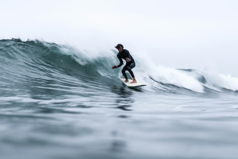 Man surfing a wave near Porto in the winter