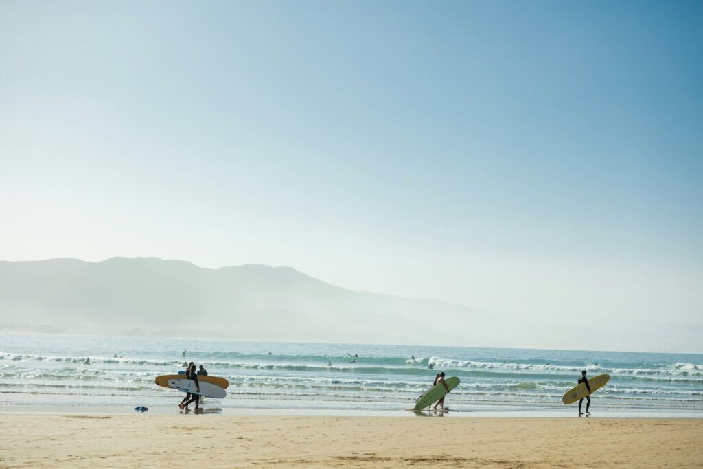 Group of surfers walking along a beach in Morocco